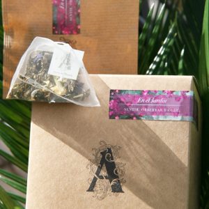 sobre paquete y pirámide de té frente palma